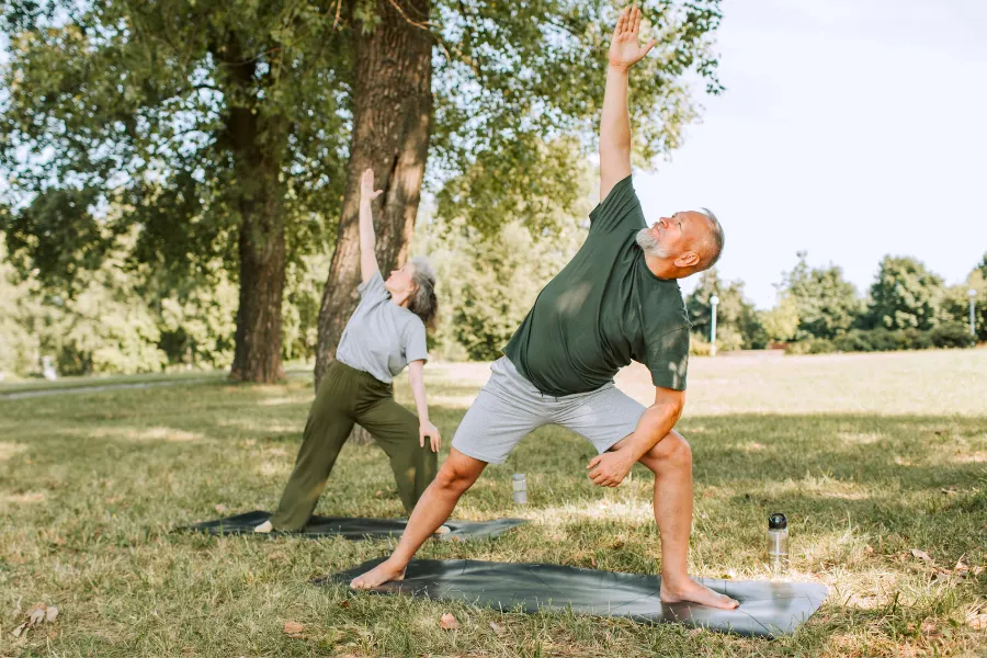 Man and woman stretching in open field