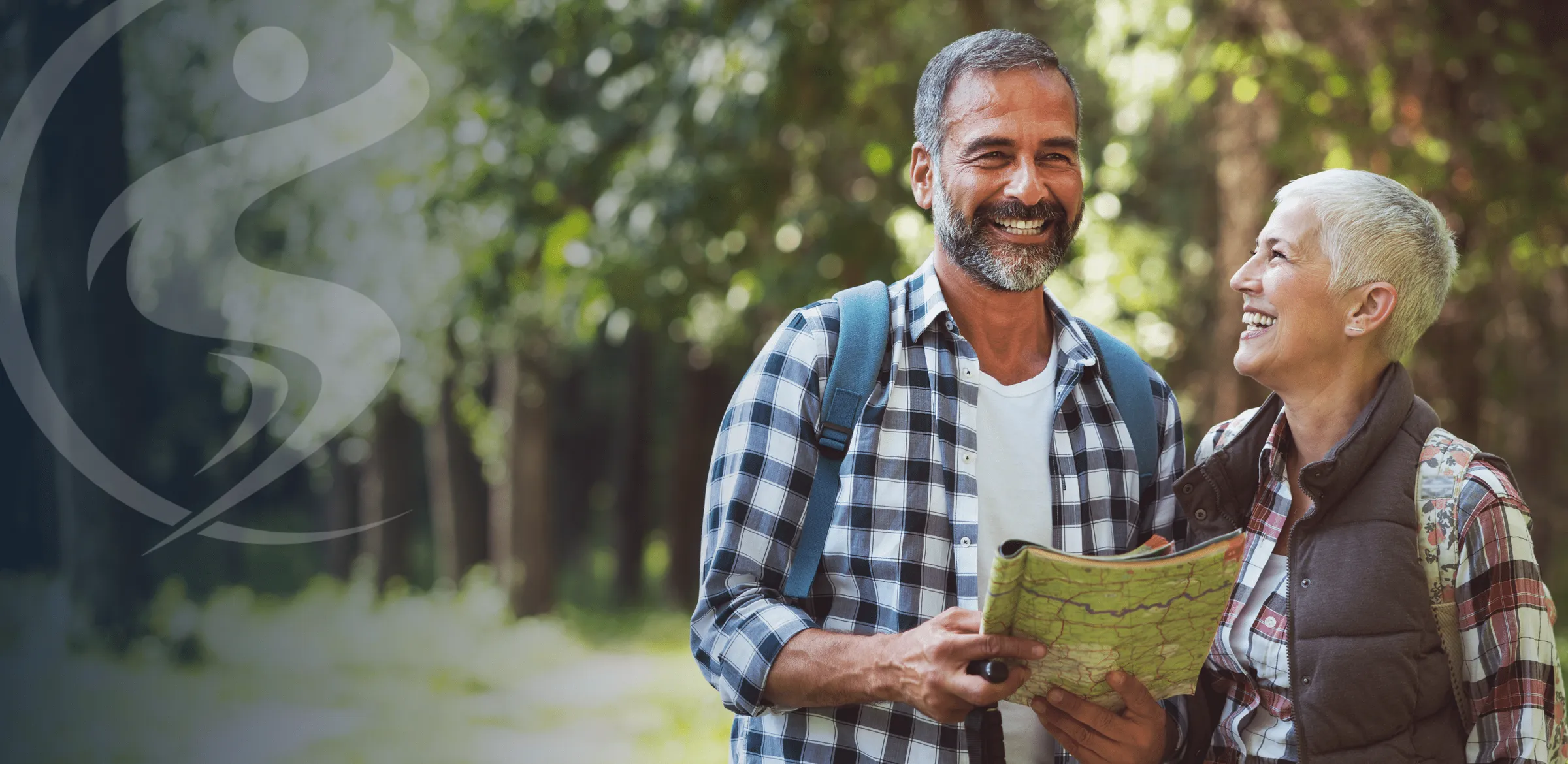 Man and woman smiling while reading a map together.