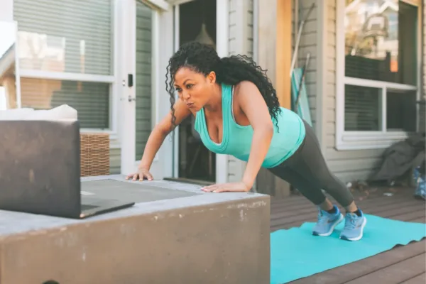 Woman with hands on exercise cube in pushup position