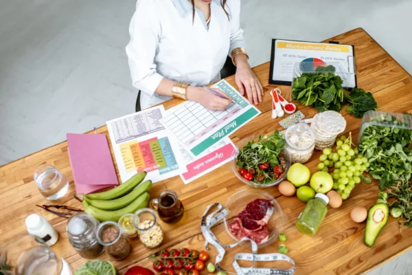 Woman with papers and healthy foods on desk
