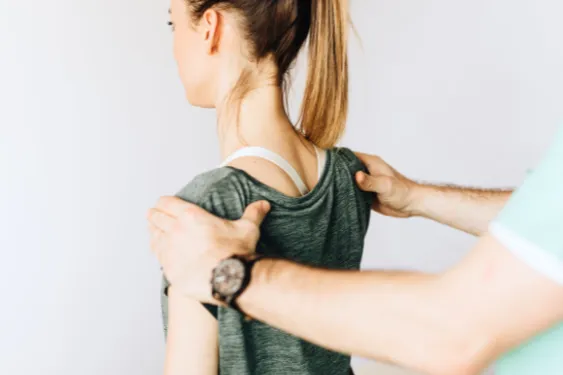 Physical therapist evaluating shoulder pain and range of motion