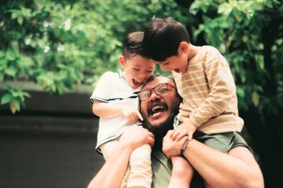 Father playing with children while experiencing shoulder pain
